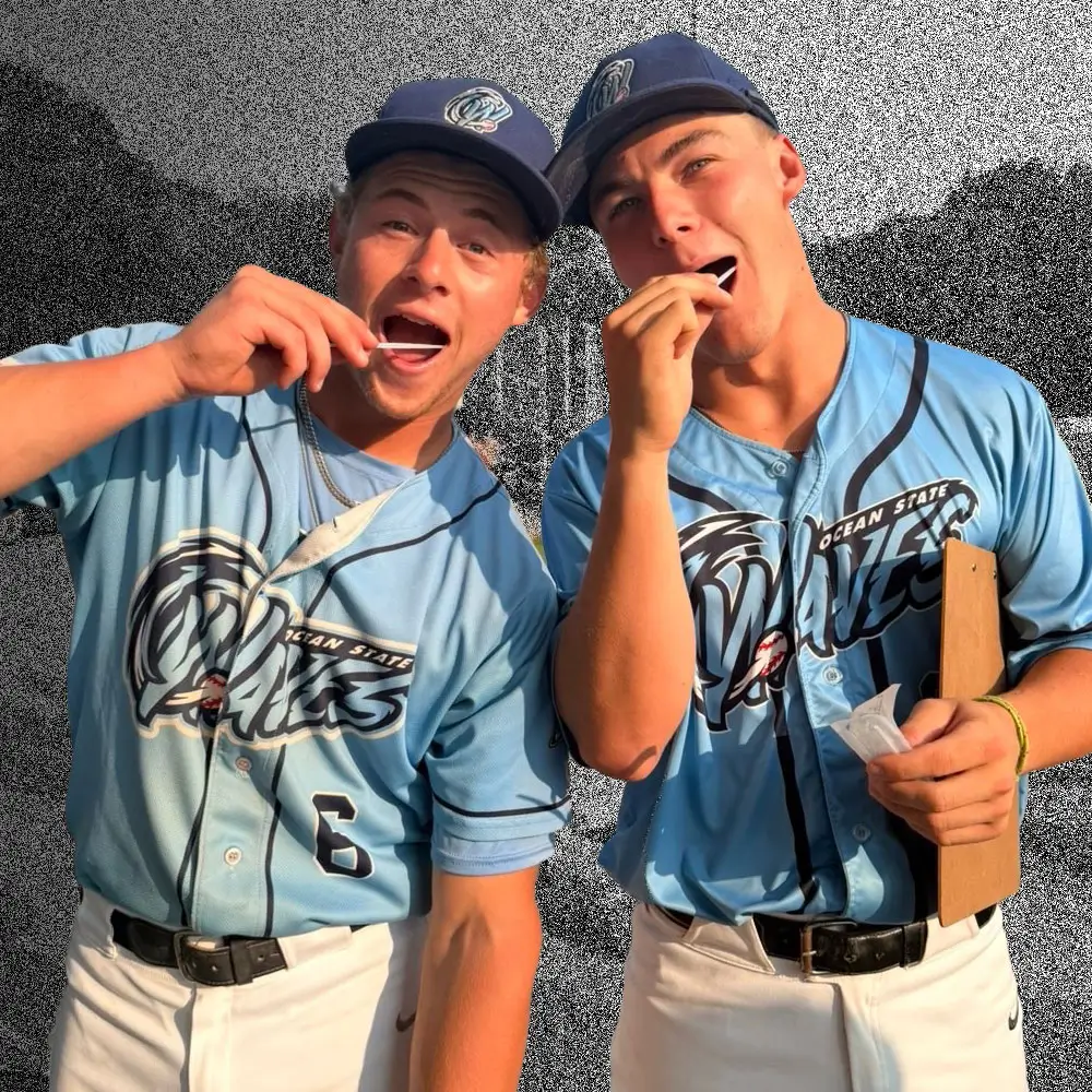 Two baseball players swabbing their cheeks at a registry drive