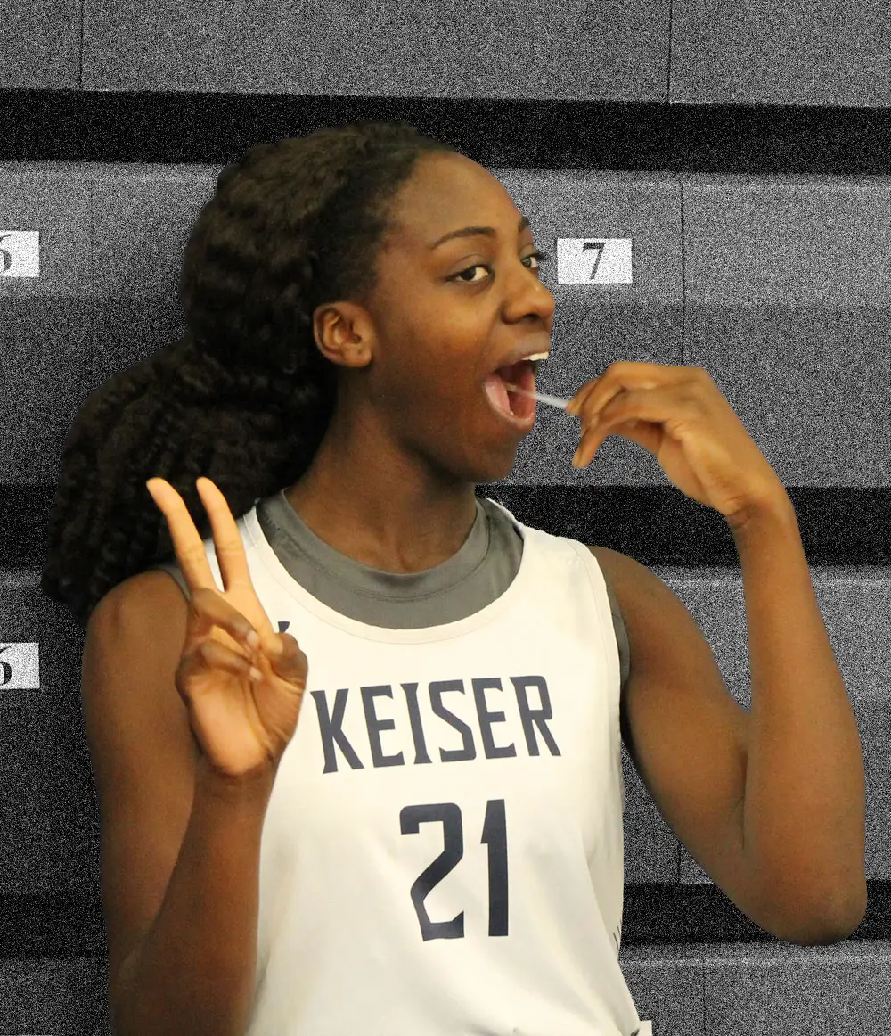 A Keiser University basketball player swabbing her cheek